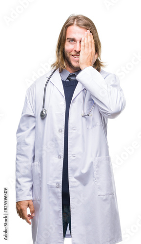 Young handsome doctor man with long hair over isolated background covering one eye with hand with confident smile on face and surprise emotion.