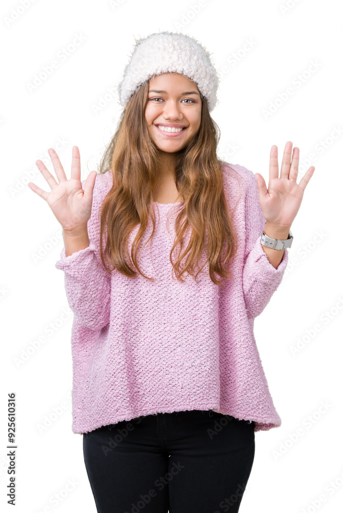 Young beautiful brunette woman wearing sweater and winter hat over isolated background showing and pointing up with fingers number ten while smiling confident and happy. Young beautiful brunette woman wearing sweater and winter hat over isolated background showing and pointing up with fingers number ten while smiling confident and happy.