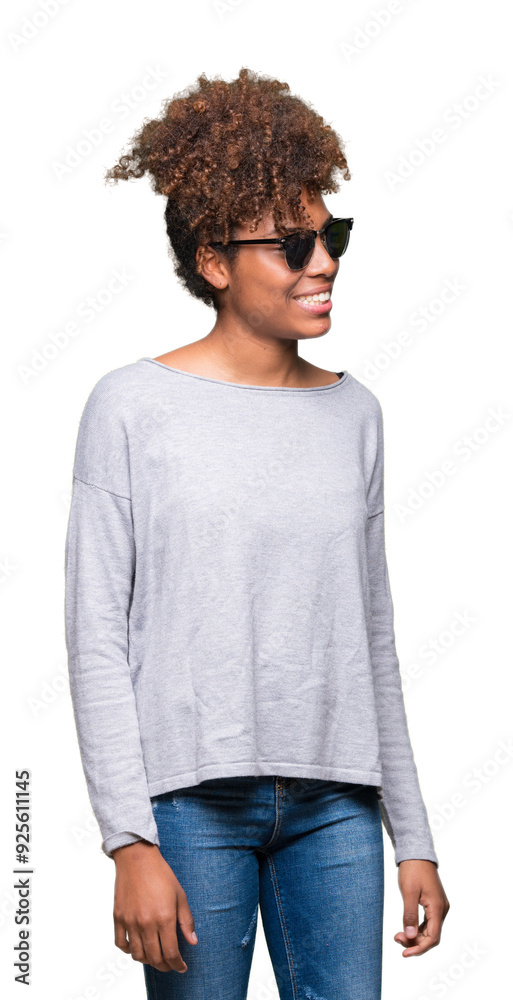 Beautiful young african american woman wearing sunglasses over isolated background looking away to side with smile on face, natural expression. Laughing confident. Beautiful young african american woman wearing sunglasses over isolated background looking away to side with smile on face, natural expression. Laughing confident.