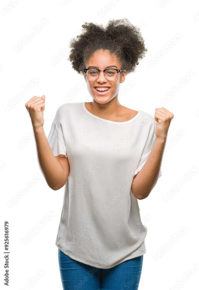 Young afro american woman wearing glasses over isolated background celebrating surprised and amazed for success with arms raised and open eyes. Winner concept. Young afro american woman wearing glasses over isolated background celebrating surprised and amazed for success with arms raised and open eyes. Winner concept.