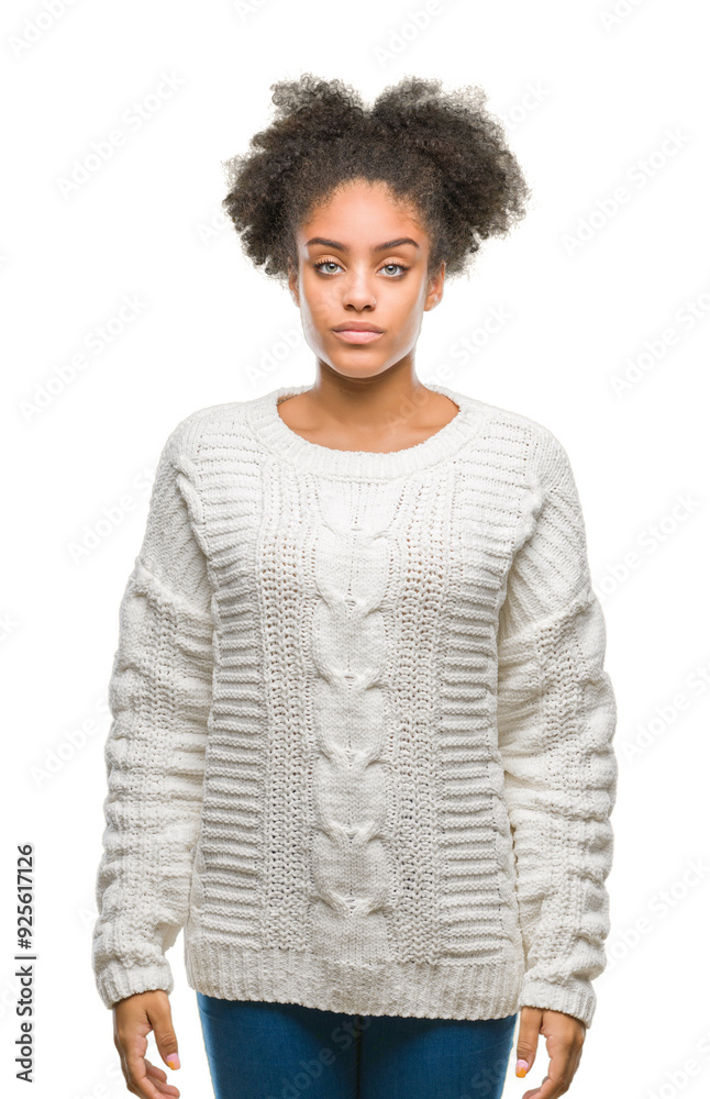 Young afro american woman wearing winter sweater over isolated background with serious expression on face. Simple and natural looking at the camera. Young afro american woman wearing winter sweater over isolated background with serious expression on face. Simple and natural looking at the camera.