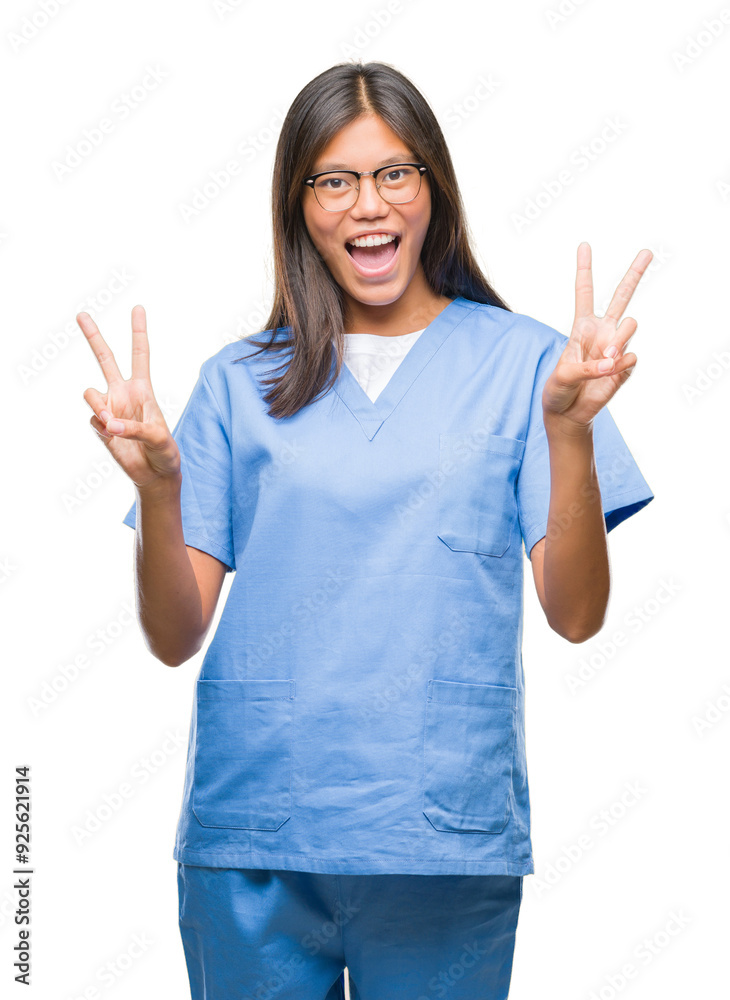 Young asian doctor woman over isolated background smiling with happy face winking at the camera doing victory sign. Number two. Young asian doctor woman over isolated background smiling with happy face winking at the camera doing victory sign. Number two.
