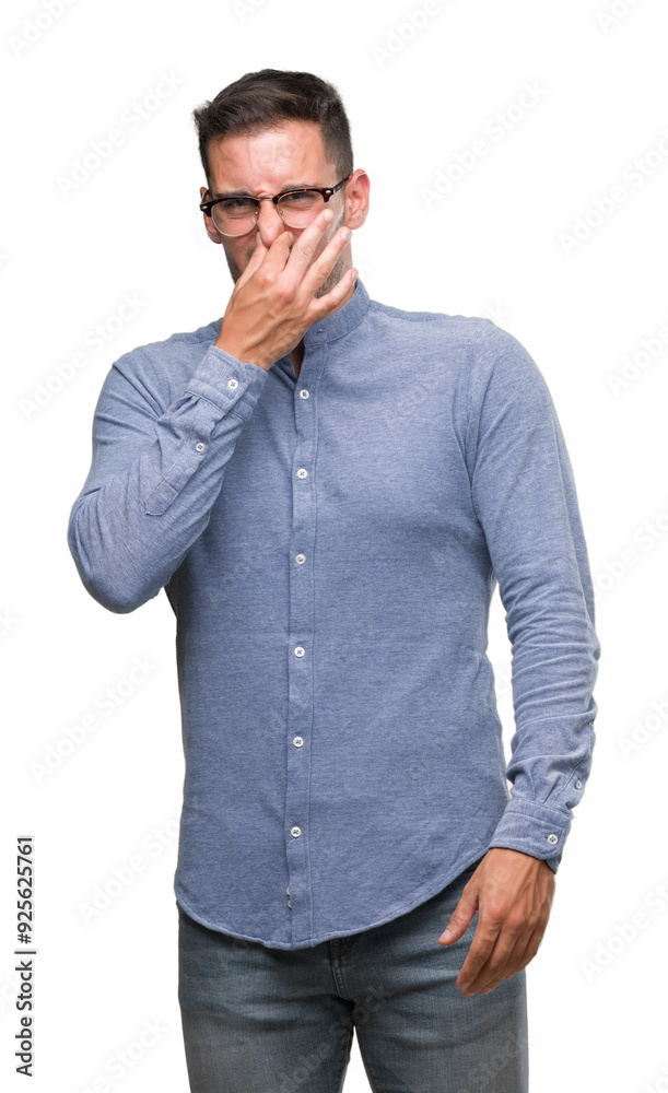 Handsome young elegant man wearing glasses smelling something stinky and disgusting, intolerable smell, holding breath with fingers on nose. Bad smells concept. Handsome young elegant man wearing glasses smelling something stinky and disgusting, intolerable smell, holding breath with fingers on nose. Bad smells concept.