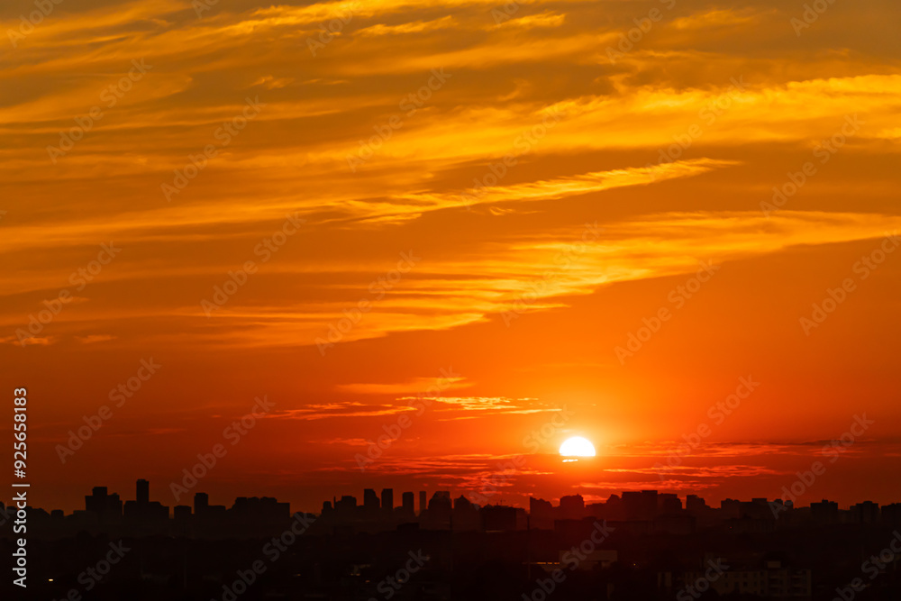 Fototapeta premium Sunset cityscape. Evening clouds and sun in the American city. Cloudscape summer nature. Clean of birds, bugs, and dust.