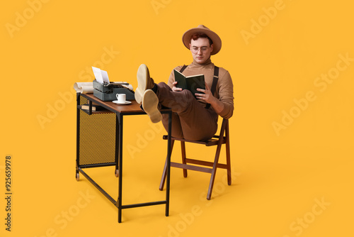 Young man reading book with...