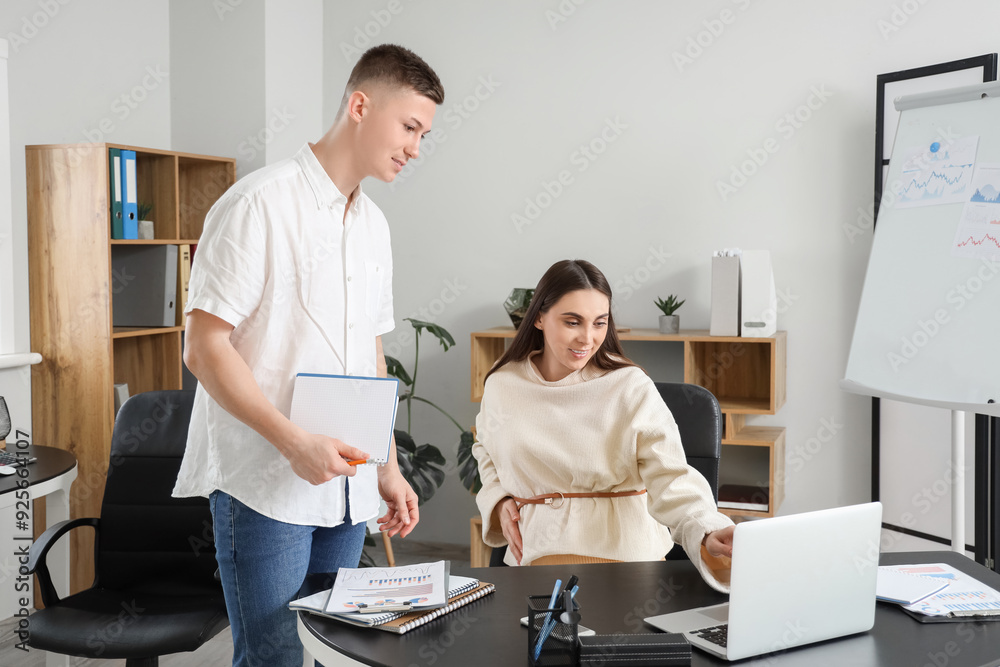 Obraz premium Pregnant businesswoman working with her colleague in office