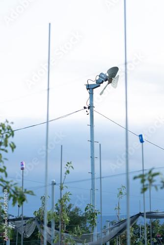 A Close-Up View of an Anti-Frost Fan Installed in an Orchard, Designed to Protect Crops from Frost Damage by Circulating Air During Cold Nights, Essential for Ensuring a Successful Harvest photo