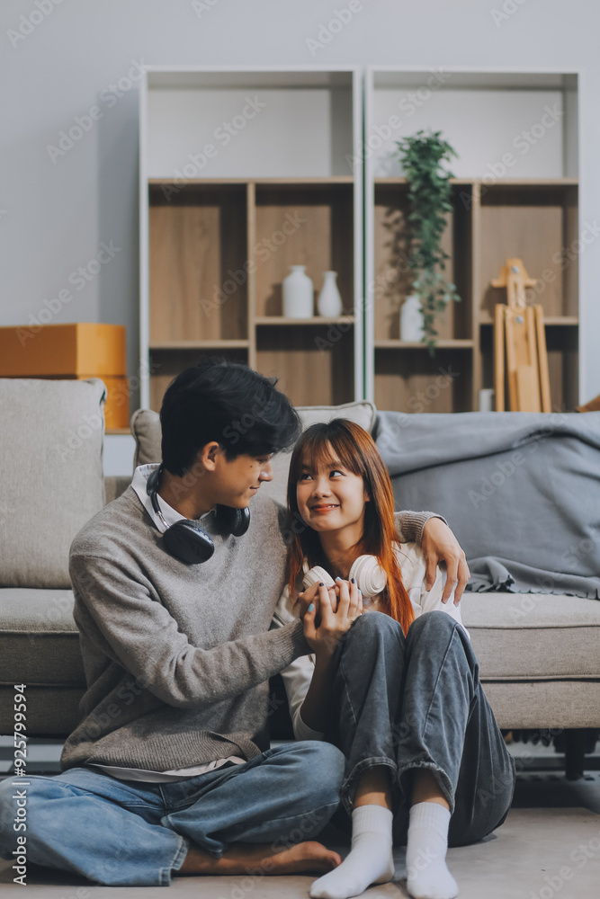 Asian Female discussing new project with male colleague. Young woman talking with young Asian man with financial on sofa in home office Asian Female discussing new project with male colleague. Young woman talking with young Asian man with financial on sofa in home office