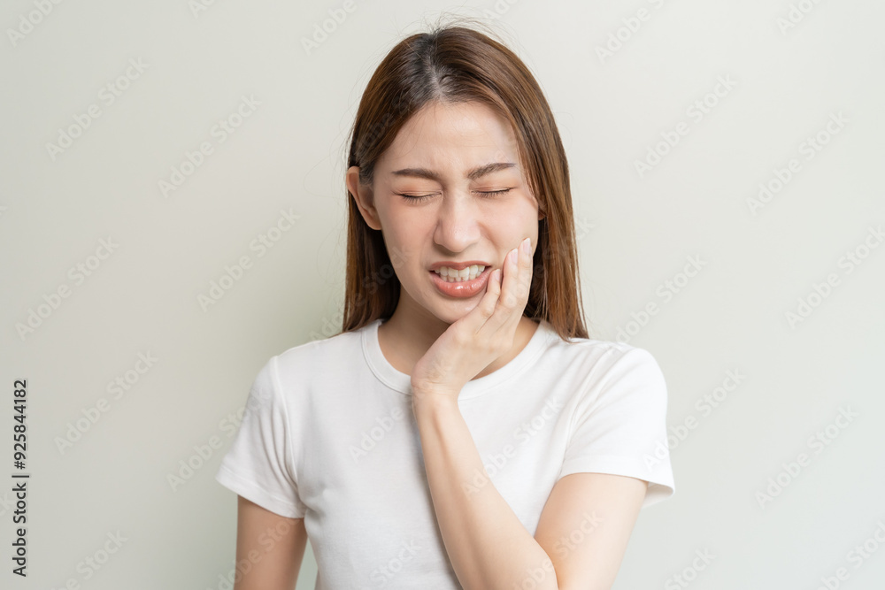 Face expression suffering from sensitive teeth, Asian young woman touching cheek