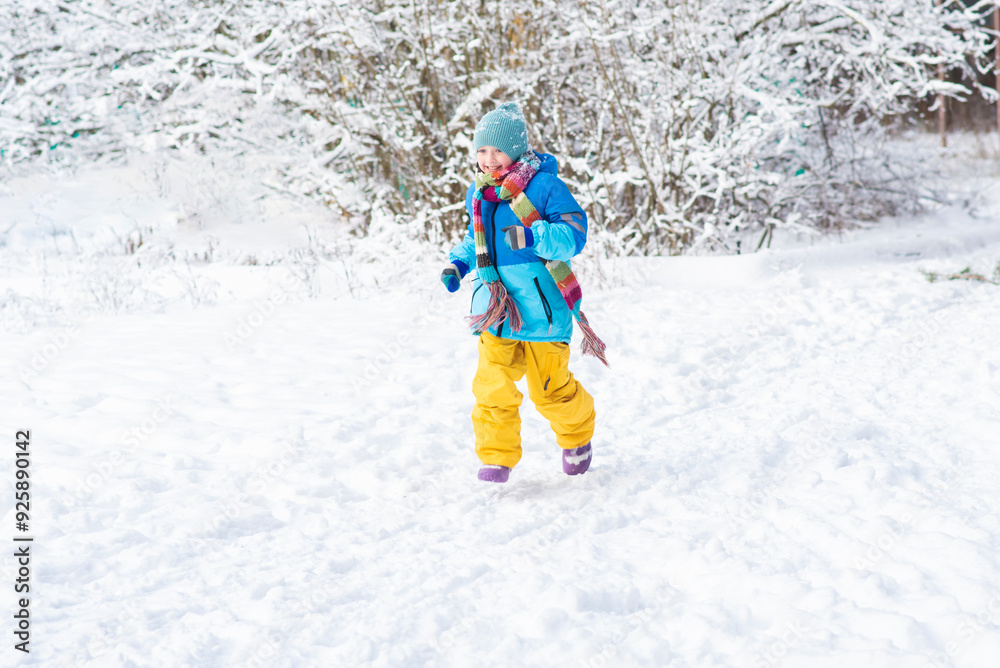 Cute little boy running in winter forest. Kid having fun outdoors. Cute little boy running in winter forest. Kid having fun outdoors.