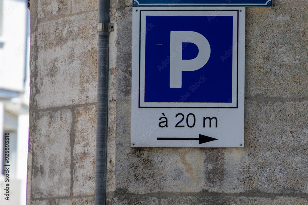 parking sign blue with text 20 meters lettering and arrow pointing left stands alone on a gray concrete wall city street parking sign blue with text 20 meters lettering and arrow pointing left stands alone on a gray concrete wall city street