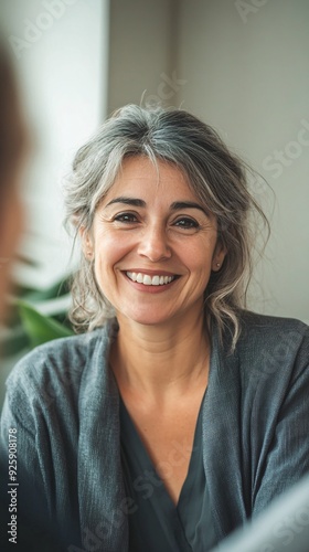 A close-up of a counseling psychologist listening attentively, with a warm smile, creating a connection with the client, light solid color background