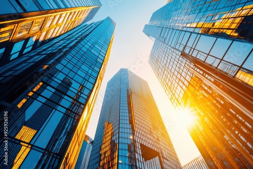 Wallpaper Mural Stunning view of modern skyscrapers reflecting golden sunlight, showcasing contemporary architecture against a clear blue sky. Torontodigital.ca