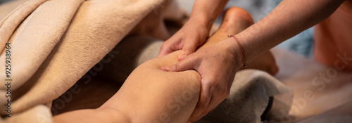 Massage therapist with client. Massage for a healthy body. Hands of a masseur on a woman's body. Leg and foot massage
