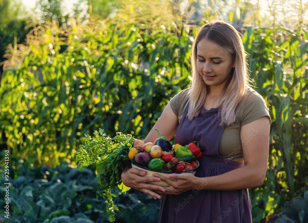 female farmer holding a large plate with various fresh farm vegetables. Autumn harvest female farmer holding a large plate with various fresh farm vegetables. Autumn harvest