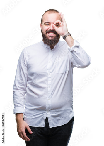 Young caucasian hispter man over isolated background doing ok gesture with hand smiling, eye looking through fingers with happy face.