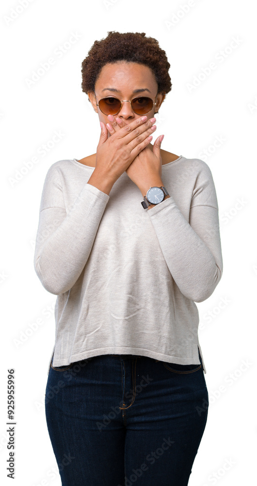 Beautiful young african american woman wearing sunglasses over isolated background shocked covering mouth with hands for mistake. Secret concept. Beautiful young african american woman wearing sunglasses over isolated background shocked covering mouth with hands for mistake. Secret concept.