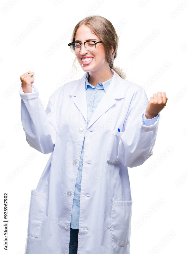 Beautiful young blonde doctor woman wearing white coat over isolated background very happy and excited doing winner gesture with arms raised, smiling and screaming for success. Celebration concept. Beautiful young blonde doctor woman wearing white coat over isolated background very happy and excited doing winner gesture with arms raised, smiling and screaming for success. Celebration concept.