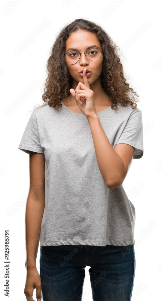 Beautiful young hispanic woman wearing glasses asking to be quiet with finger on lips. Silence and secret concept. Beautiful young hispanic woman wearing glasses asking to be quiet with finger on lips. Silence and secret concept.