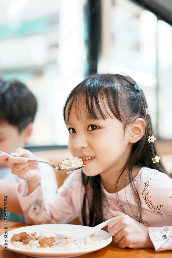 Happy little boy and girl have lunch. Children eating by self. Selective focus.