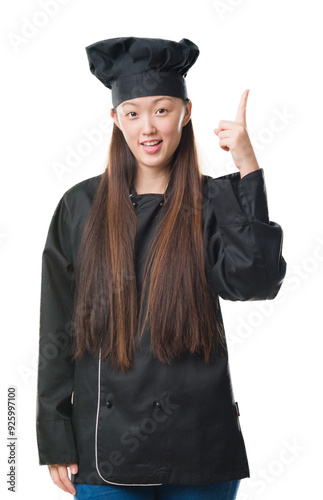 Young Chinese woman over isolated background wearing chef uniform pointing finger up with successful idea. Exited and happy. Number one.