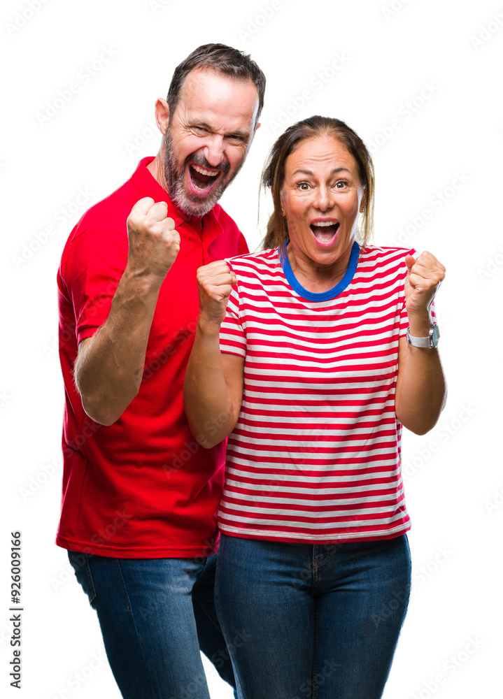 Middle age hispanic couple in love over isolated background celebrating surprised and amazed for success with arms raised and open eyes. Winner concept.