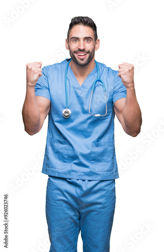 Handsome young doctor surgeon man over isolated background celebrating surprised and amazed for success with arms raised and open eyes. Winner concept.