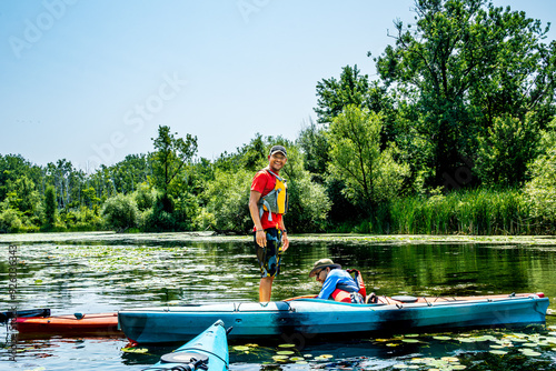 Photography Learning to sea kayak: two paddlers practice standing in a sea kayak on a pond i