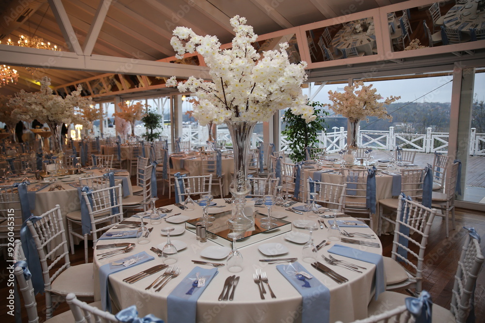 Elegant wedding reception with round tables, white chairs, and floral centerpieces