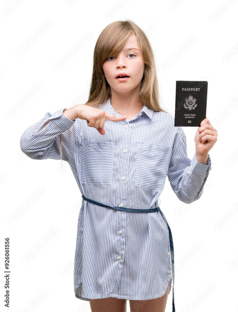 Young blonde toddler holding american passport very happy pointing with hand and finger Young blonde toddler holding american passport very happy pointing with hand and finger