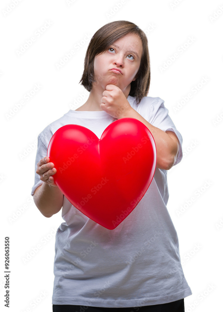 Young adult woman with down syndrome holding red heart over isolated background serious face thinking about question, very confused idea Young adult woman with down syndrome holding red heart over isolated background serious face thinking about question, very confused idea