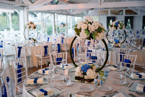 Obraz na płótnie A beautifully decorated wedding reception with round tables adorned with white flowers and blue accents w salonie