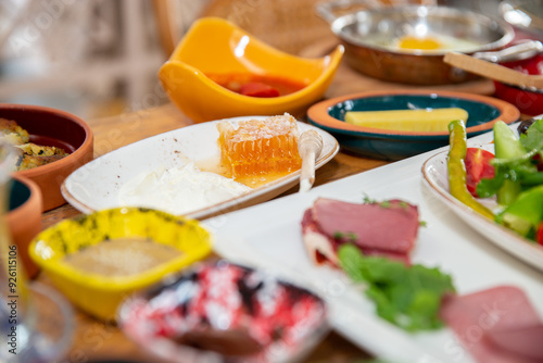 A traditional Turkish breakfast spread with various cheeses, meats, and fresh vegetables