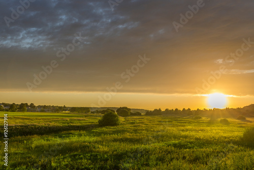 A field of grass with a large sun in the sky