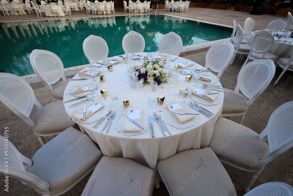 Elegant Poolside Wedding Reception with Round Tables and White Chairs