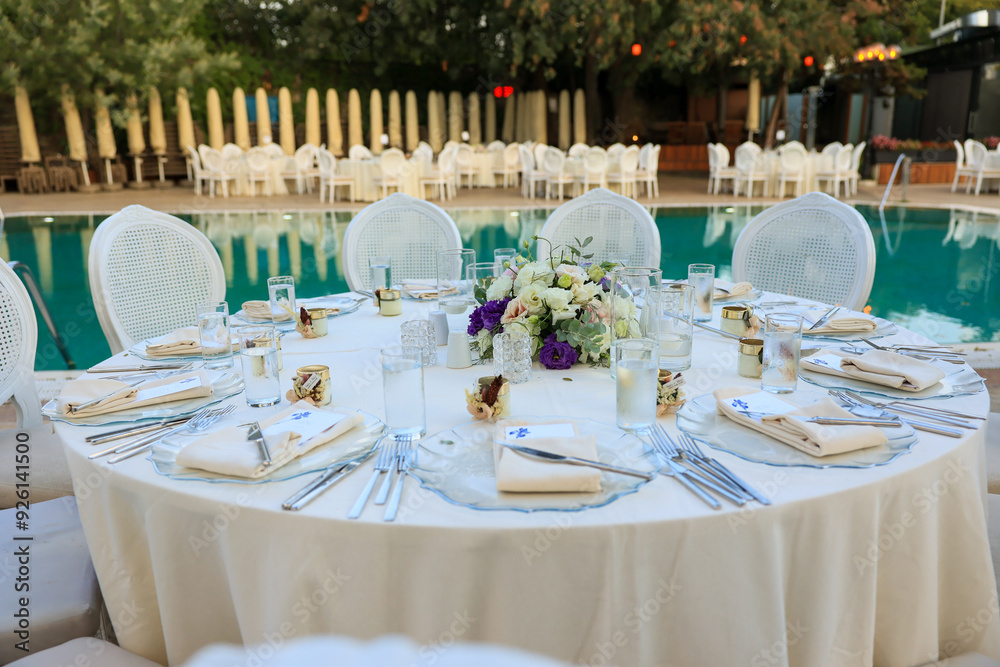 Elegant Poolside Wedding Reception with Round Tables and White Chairs