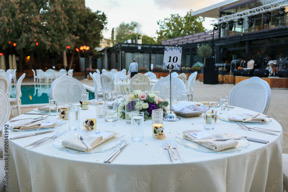 Elegant Poolside Wedding Reception with Round Tables and White Chairs
