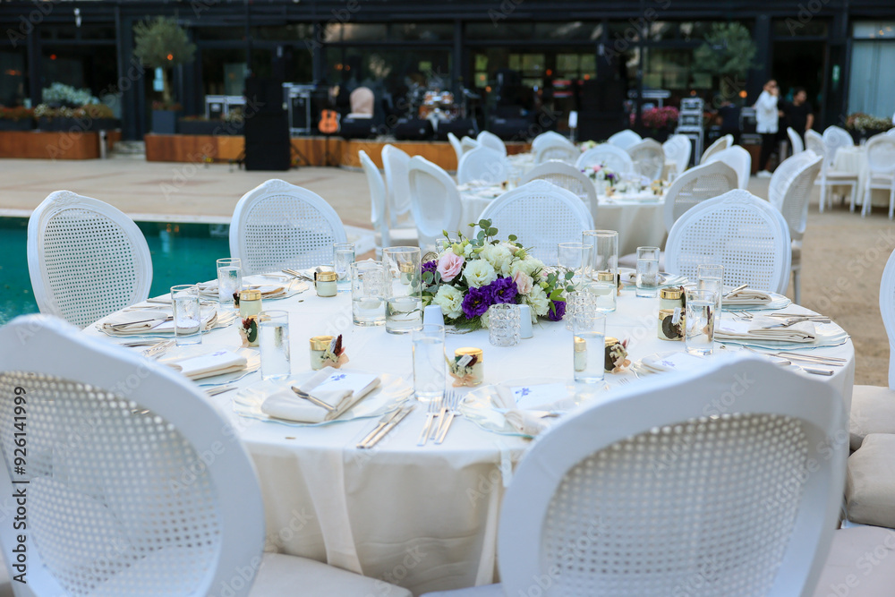 Elegant Poolside Wedding Reception with Round Tables and White Chairs