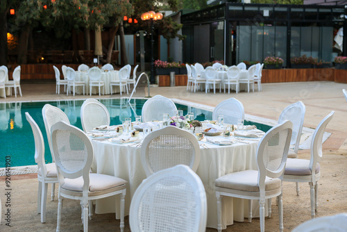 Obraz na płótnie Elegant Poolside Wedding Reception with Round Tables and White Chairs w salonie