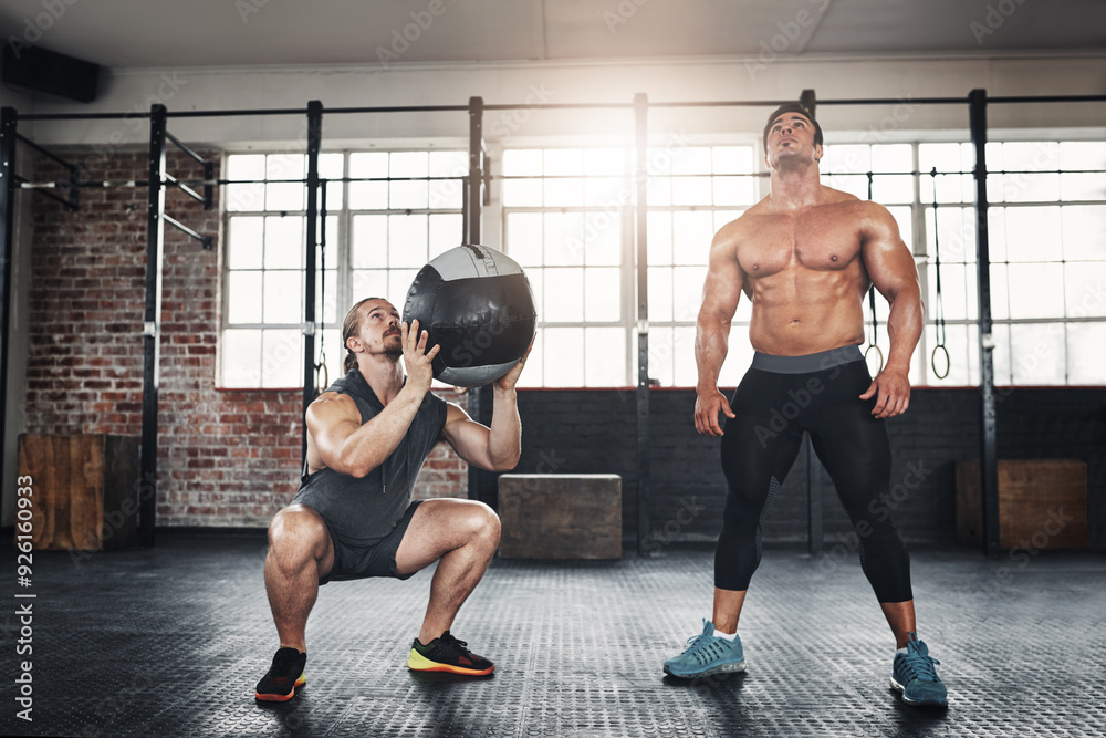 Fototapeta premium Men, friends and throw medicine ball at gym for bodybuilding with strength and determination. Workout, muscles and strong as body builder on training, fitness and exercise for health and self care