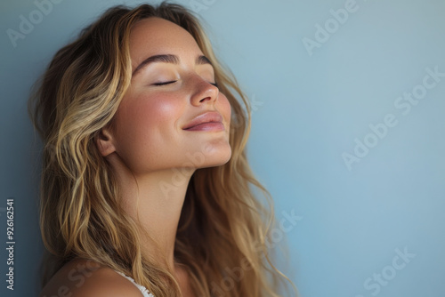 A close up of a woman's face with her eyes closed and long blond hair