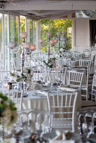 Elegant round dining table with white tablecloth, candles, and floral centerpiece, overlooking a beautiful view