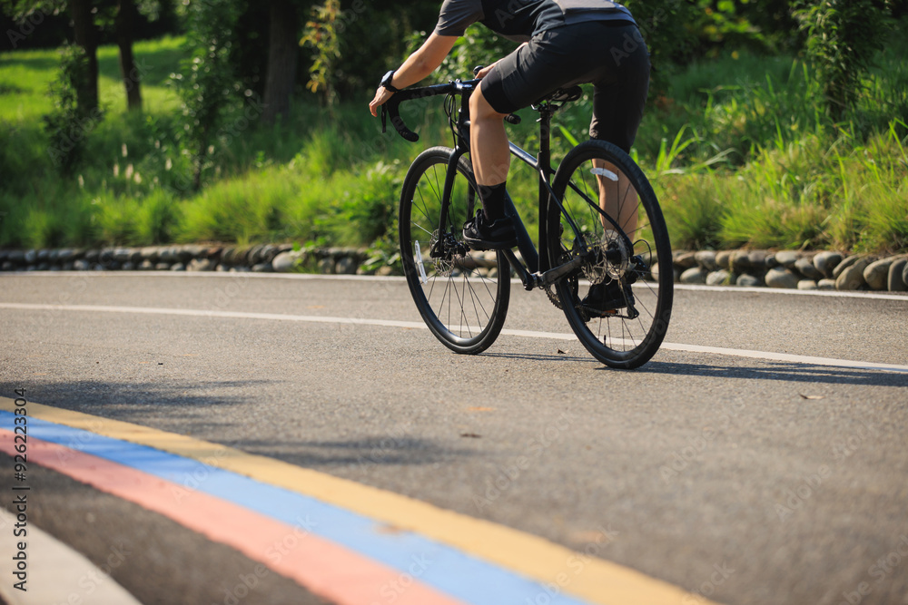Obraz premium Woman cyclist riding bike at summer park