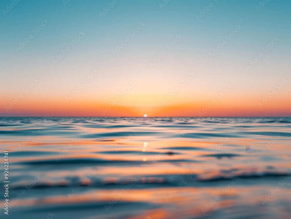 A serene sunset over the ocean with gentle waves lapping at the shore. The sky is a beautiful blend of orange, pink, and blue. A serene sunset over the ocean with gentle waves lapping at the shore. The sky is a beautiful blend of orange, pink, and blue.