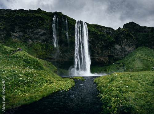 Seljalandsfoss als schmaler isländischer Wasserfall mit einem Fluss im Vordergrund 