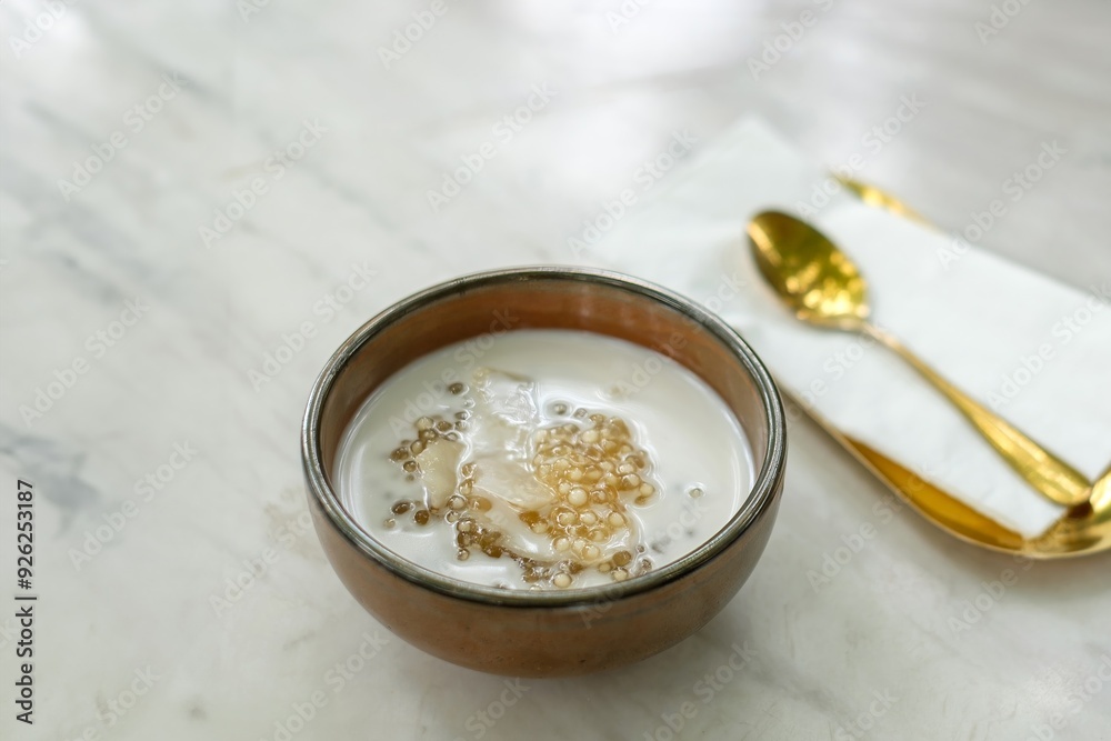 A Bowl of Oatmeal with Banana Slices and a Gold Spoon on a Marble Table, Representing a Healthy Breakfast. A Bowl of Oatmeal with Banana Slices and a Gold Spoon on a Marble Table, Representing a Healthy Breakfast.