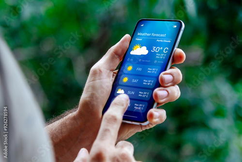 Man outdoors checking weather forecast on his mobile phone.