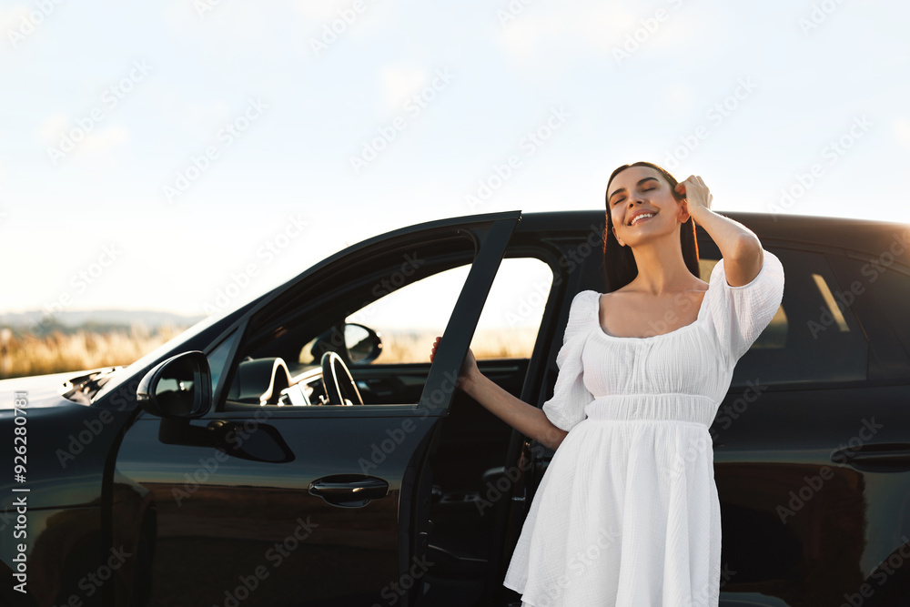 Smiling young woman near car at sunset Smiling young woman near car at sunset
