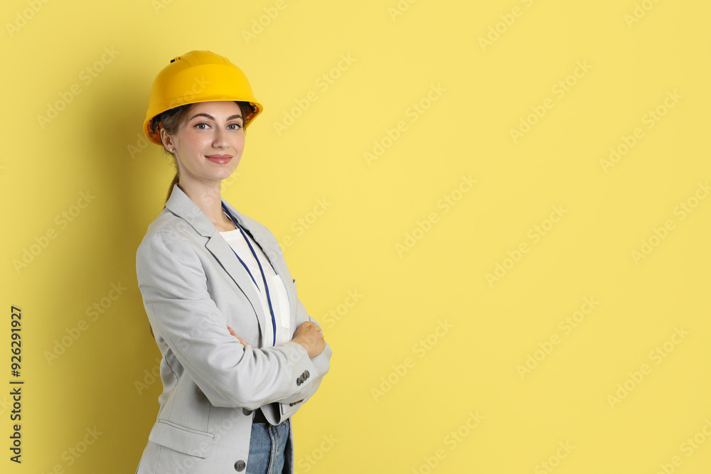 Engineer in hard hat on yellow background, space for text Engineer in hard hat on yellow background, space for text
