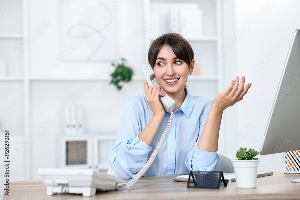 Portrait of receptionist at wooden desk in office